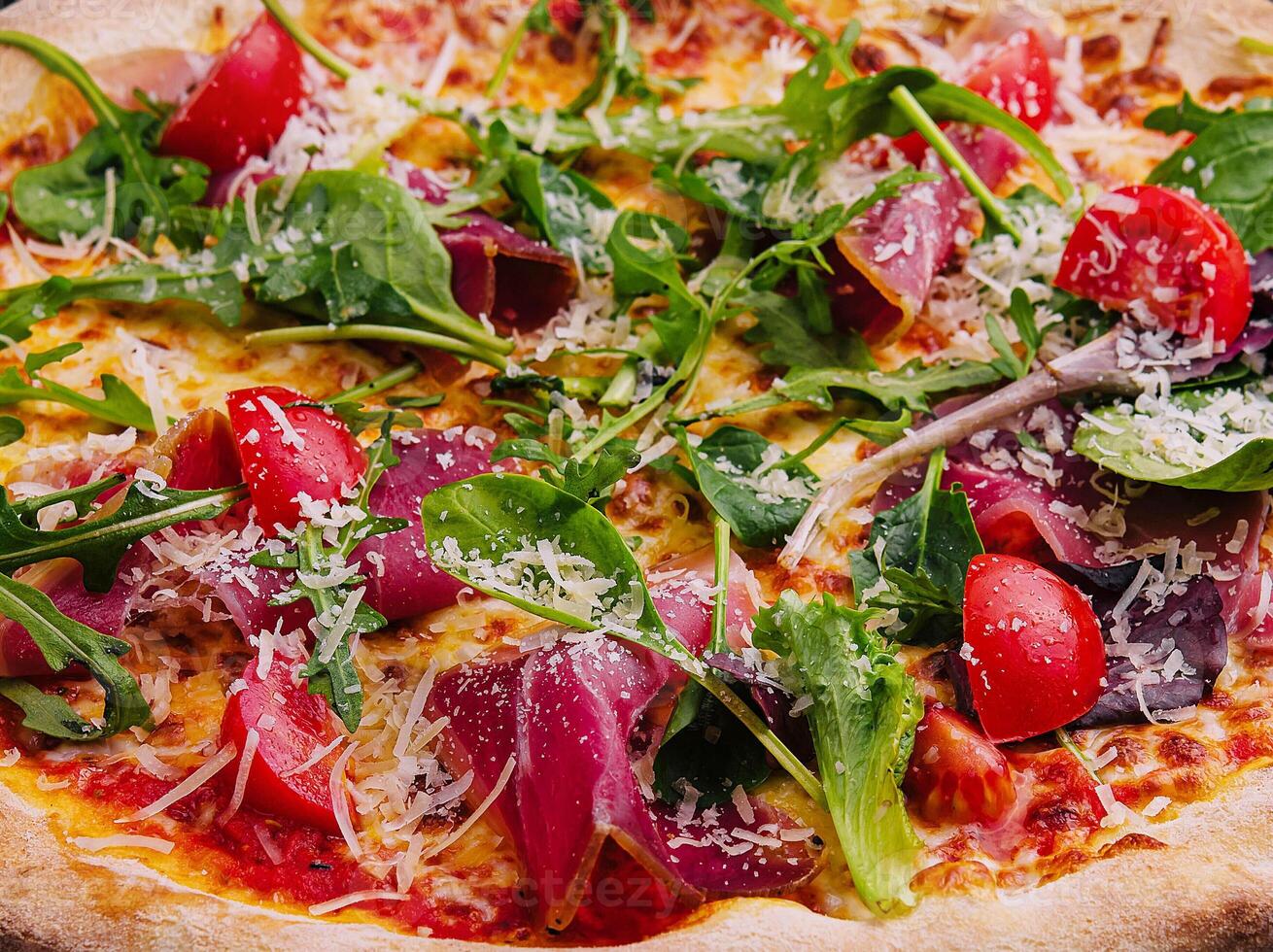 italiano Pizza con prosciutto, rucola e ciliegia pomodori foto