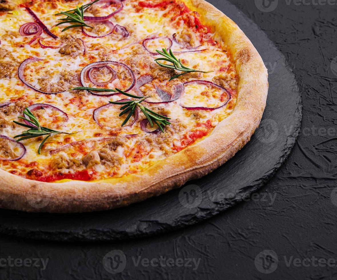 Pizza con tonno e rosso cipolla su pietra taglio tavola foto