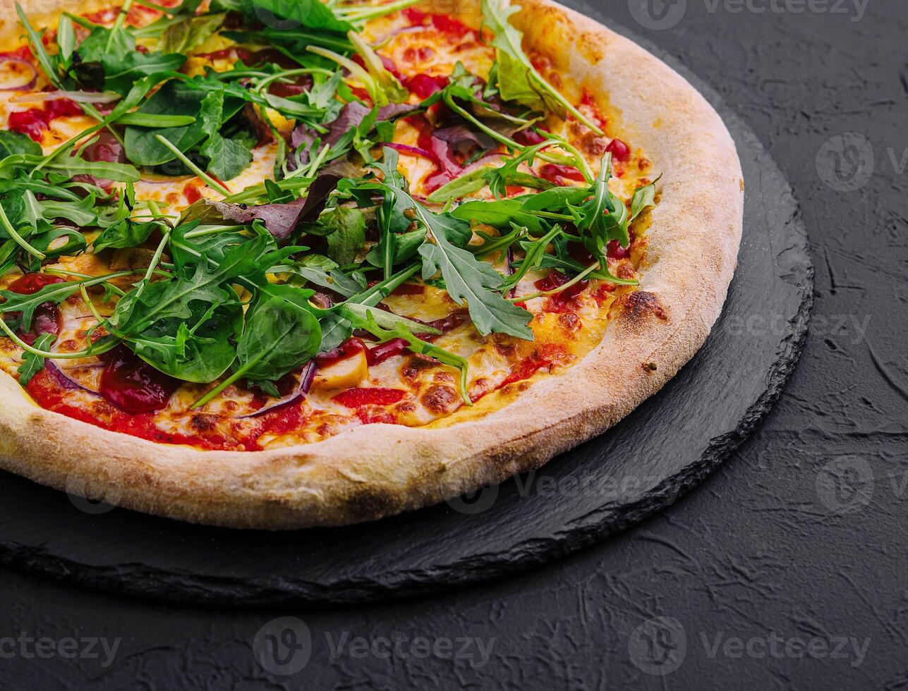 Pizza con rucola su nero tavola foto