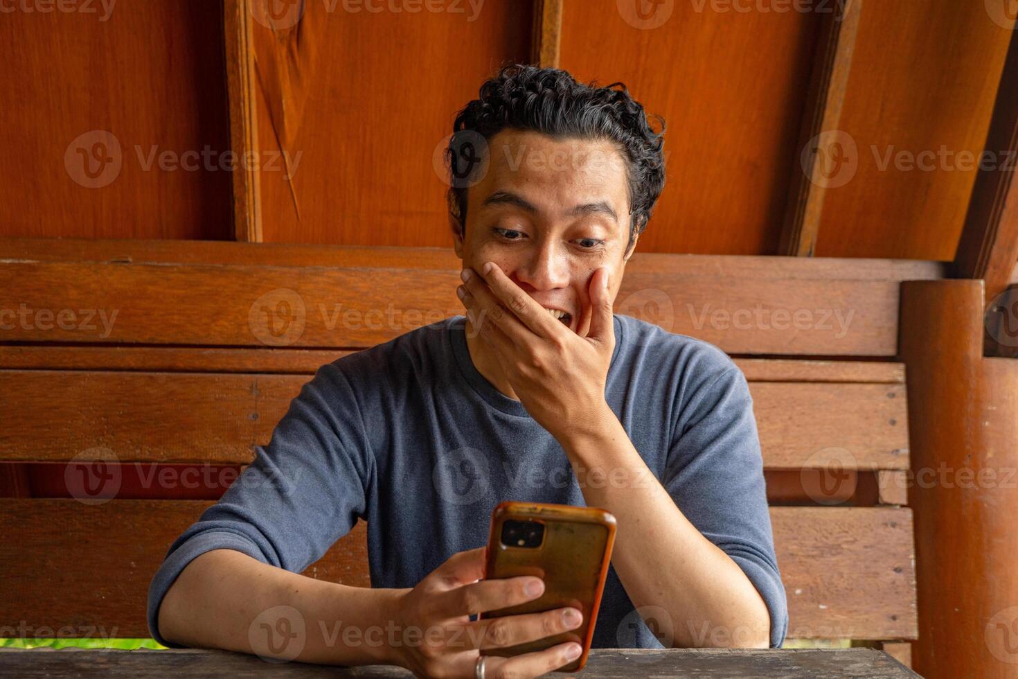 uomo Sorridi contento e sorpreso quando guardare a Telefono su il ristorante. il foto è adatto per uso per espressione pubblicità e e-commerce.