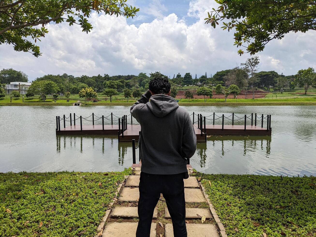 uomo In piedi nel davanti di il modo lago su giù cittadina. il foto è adatto per uso per avventura soddisfare media, natura manifesto e foresta sfondo.