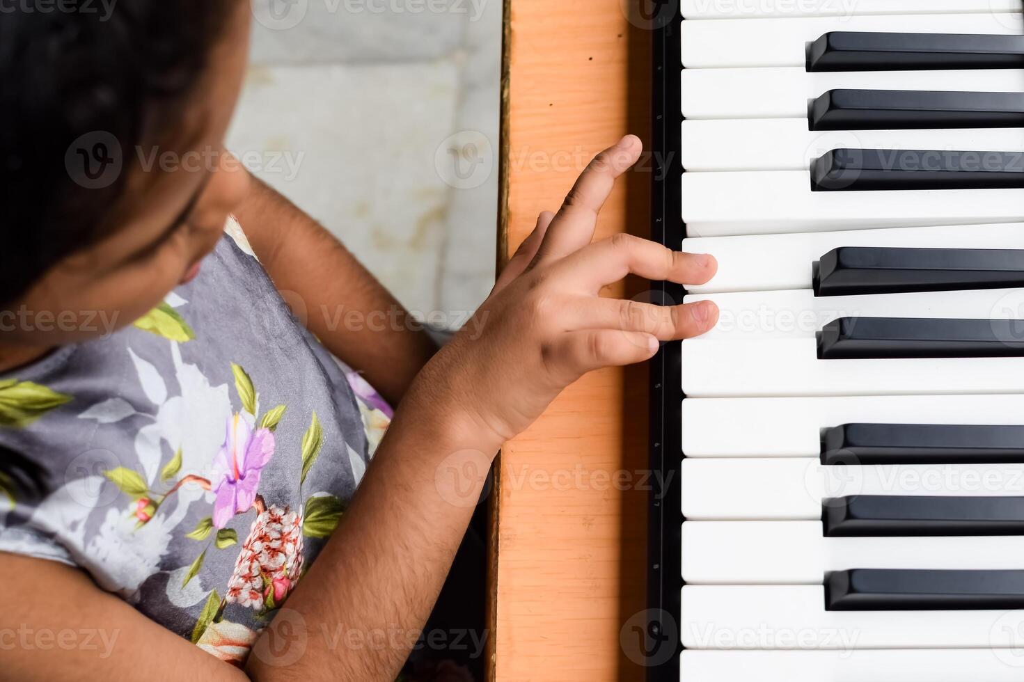 asiatico carino ragazza giocando il sintetizzatore o pianoforte. carino poco ragazzo apprendimento Come per giocare pianoforte. del bambino mani su il tastiera interno. foto