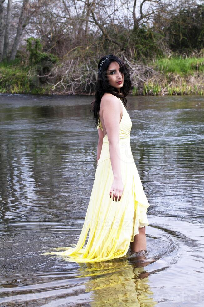 giovane est indiano donna in piedi nel fiume foto