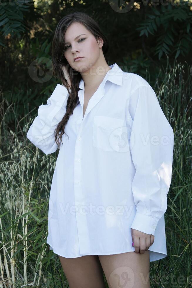 caucasico donna in piedi nel bianca vestito camicia all'aperto foto