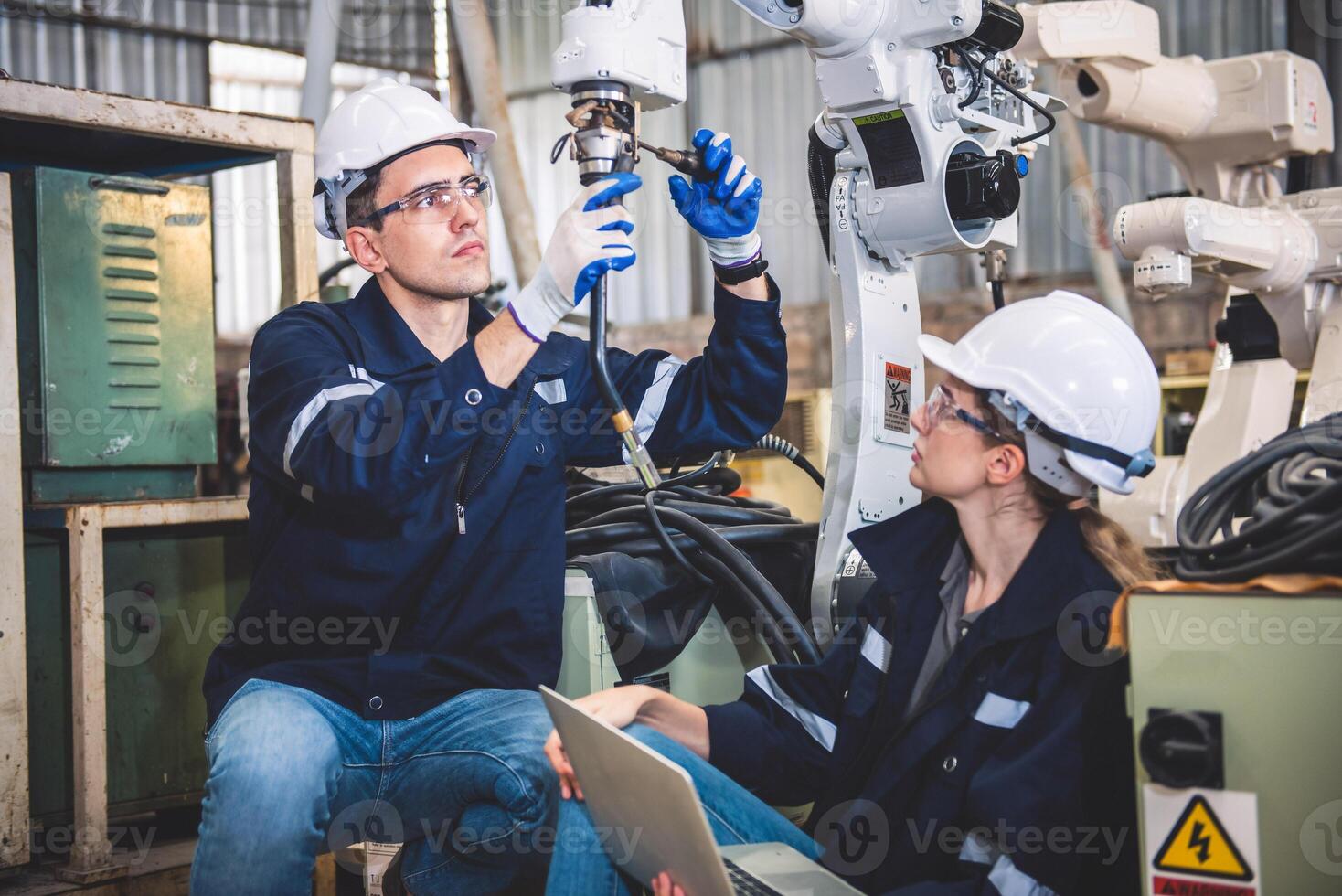 ingegneri squadra meccanico utilizzando computer controllore robotica braccio per saldatura acciaio nel acciaio fabbrica officina. industria robot programmazione Software per automatizzato produzione tecnologia foto