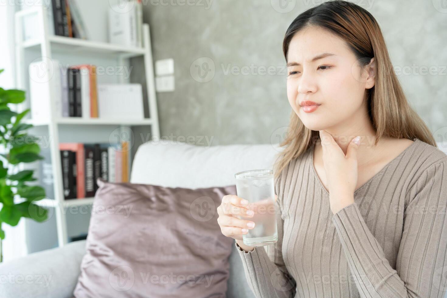 asiatico donna mettere sua mano su sua collo dovuto per un' dolorante gola. femmina tonsillite cause un' infiammazione. trattati di assunzione acqua, assunzione antibiotici, consultare un' medico, virus, corona virus, influenza, influenza foto