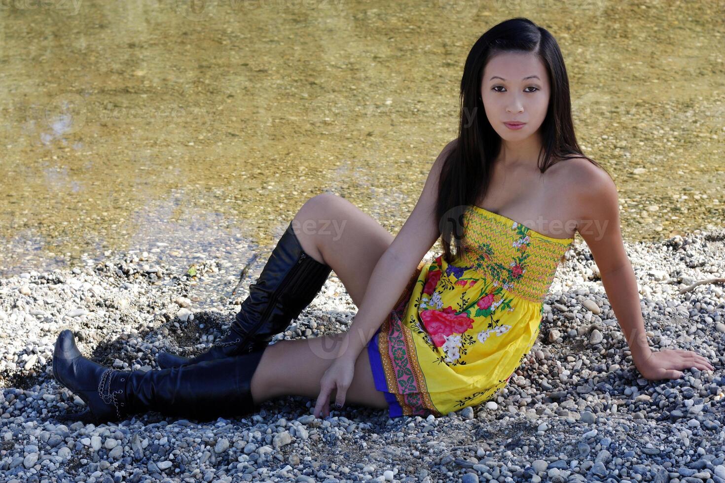 giovane asiatico americano donna giallo vestito fiume foto