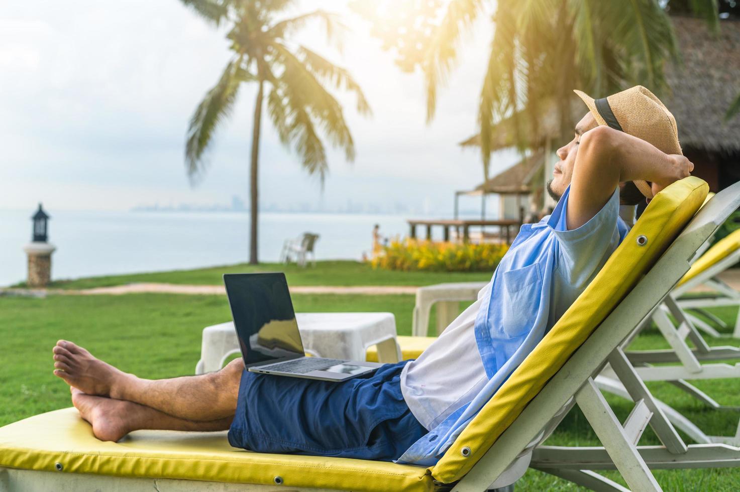 L'uomo che utilizza il computer portatile sulla spiaggia mare e uomo viaggio vacanza phuket island sandbox thailandia sono libertà vita finanziaria foto