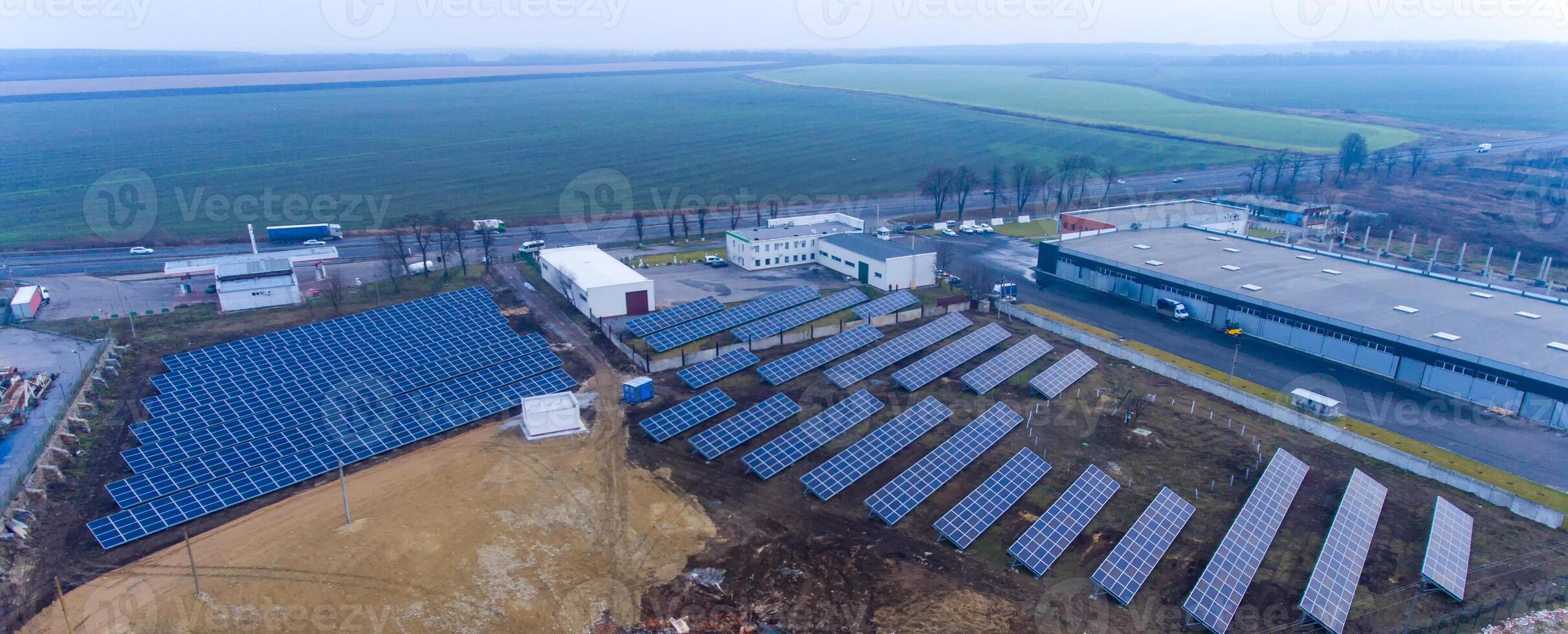 magazzino tetto Usato per un installazione di numerose solare energia stazioni. villaggio e agricolo campo a il sfondo. foto