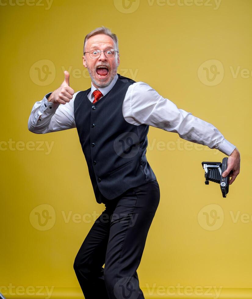 divertente anziano uomo fa autoscatto di il suo culo su giallo sfondo. divertente emozioni. foto