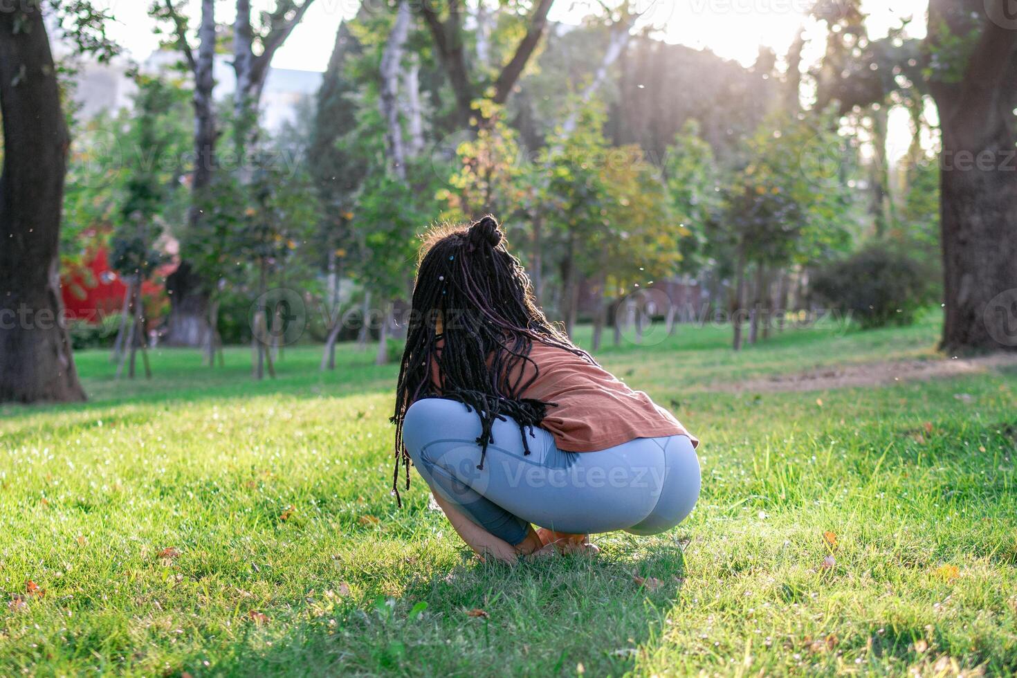 giovane europeo donna è seduta su un' erba e fare yoga esercizio. salutare stile di vita all'aperto. foto
