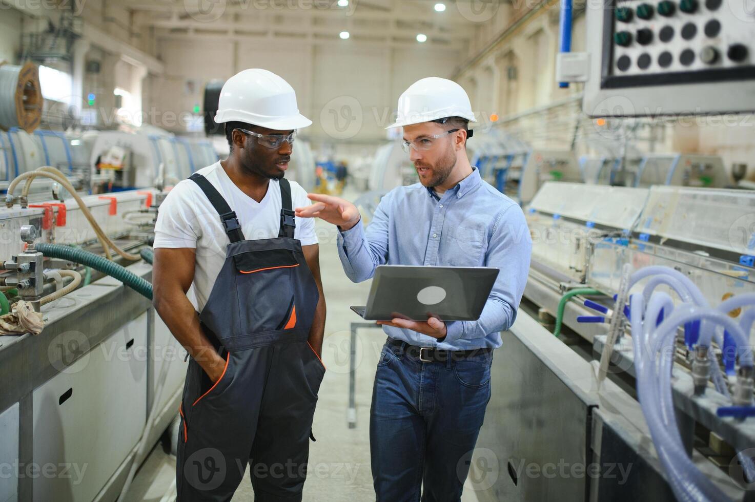 un ingegnere comunica con un' lavoratore su un' produzione linea foto