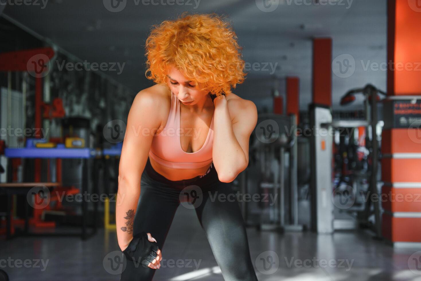 fitness ragazza con forte corpo avendo rompere fra cardio allenamento. sportivo donna nel moda abbigliamento sportivo riposo dopo intenso esercizio. in forma femmina con muscolare corpo guardare stanco. foto