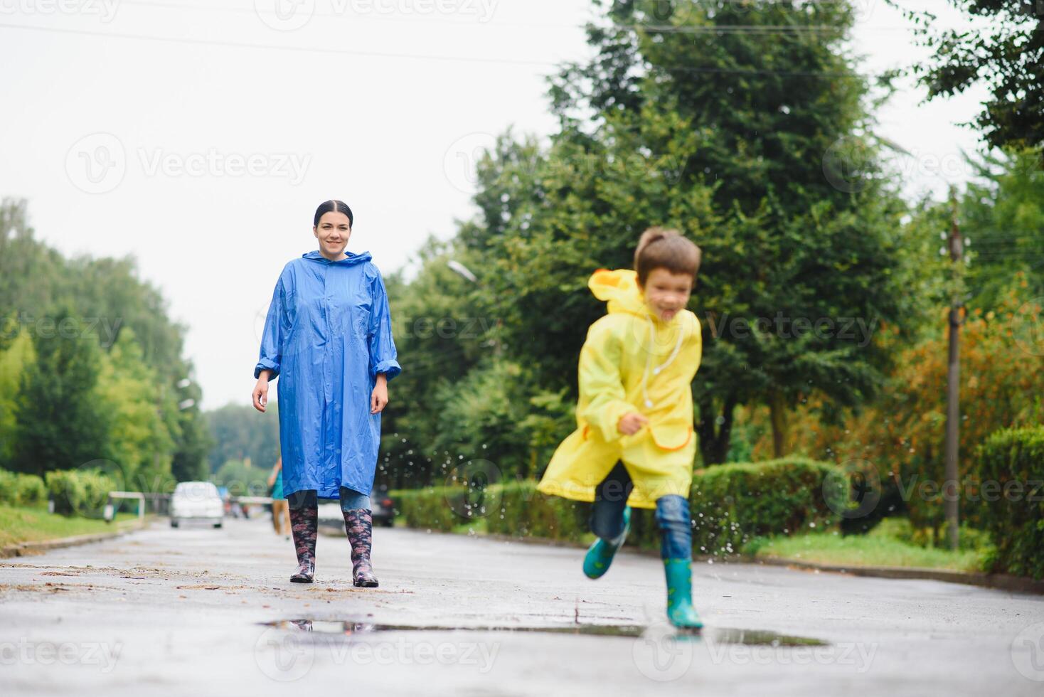 mamma e figlio nel impermeabili avere divertimento insieme nel il pioggia. concetto di famiglia vacanza e contento infanzia. foto