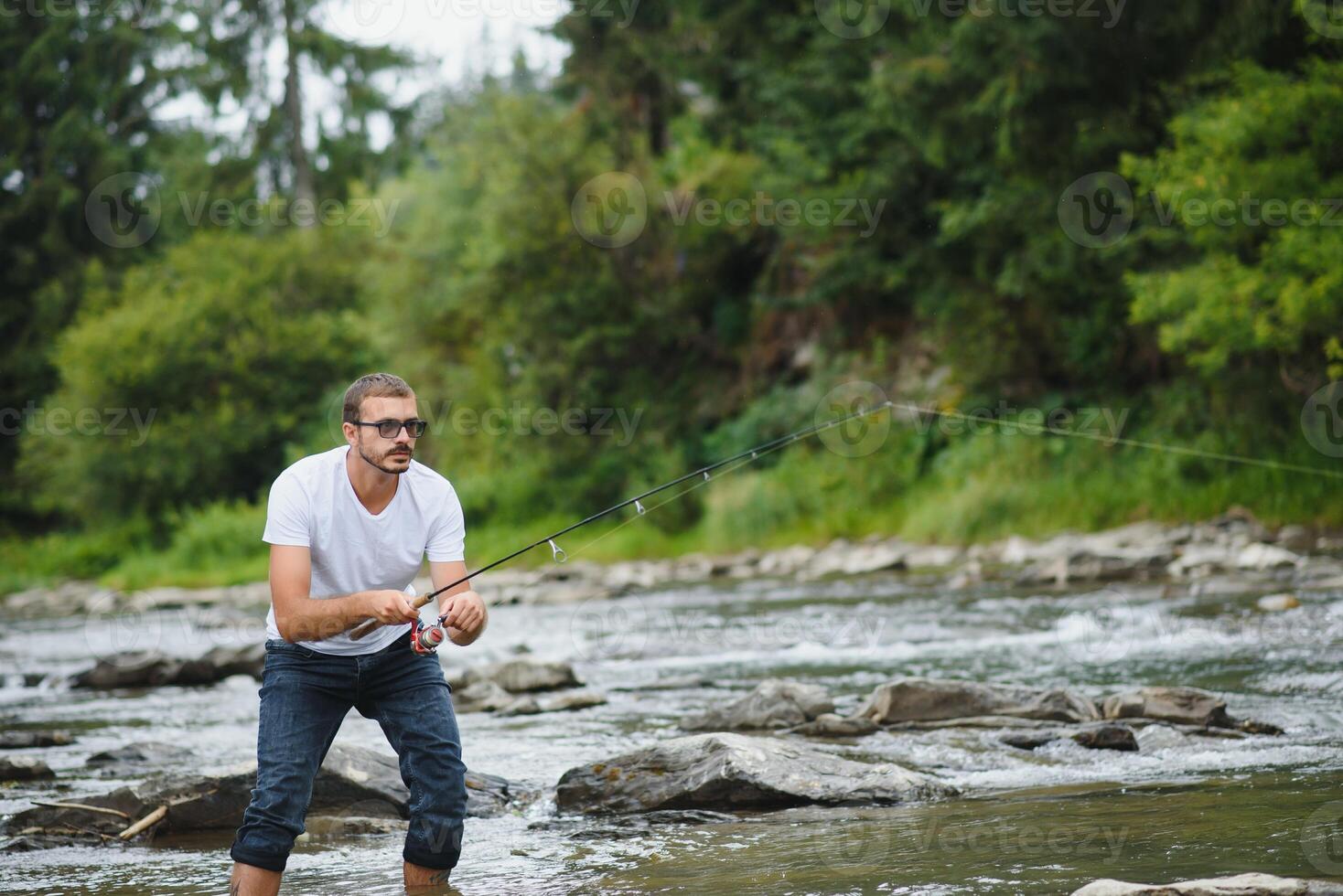 barbuto uomo attraente pesce. estate tempo libero. maturo uomo pesca su il stagno. ritratto di allegro anziano uomo pesca. maschio pesca. pescatore uncinetto rotazione in il fiume in attesa grande pesce foto