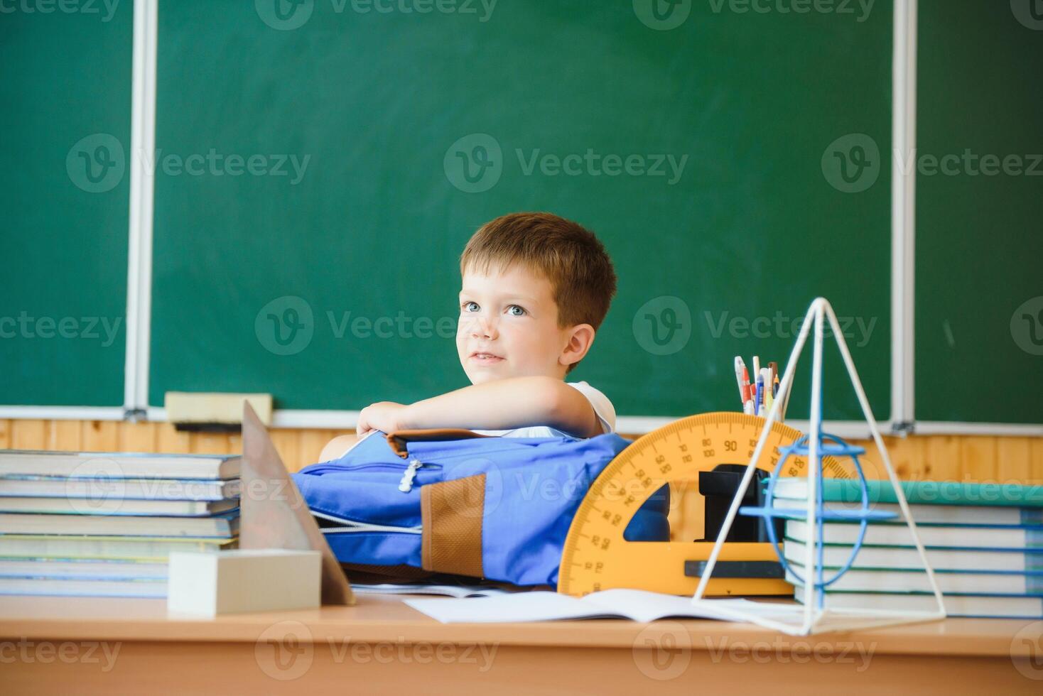 formazione scolastica e apprendimento. poco scolaro nel aula. scolaro fare compiti a casa nel aula a scuola. elementare scuola ragazzo seduta a scrivania. formazione scolastica. ragazzo a scuola. foto