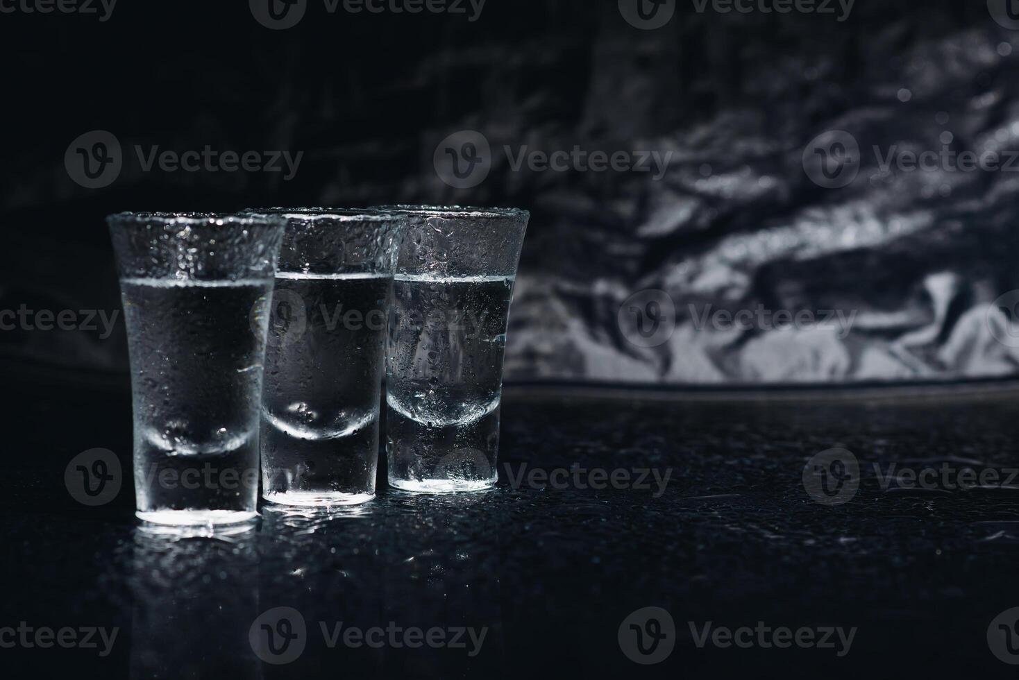 Vodka. colpi, bicchieri con Vodka con ghiaccio .scuro sfondo. copia spazio .selettivo messa a fuoco. foto