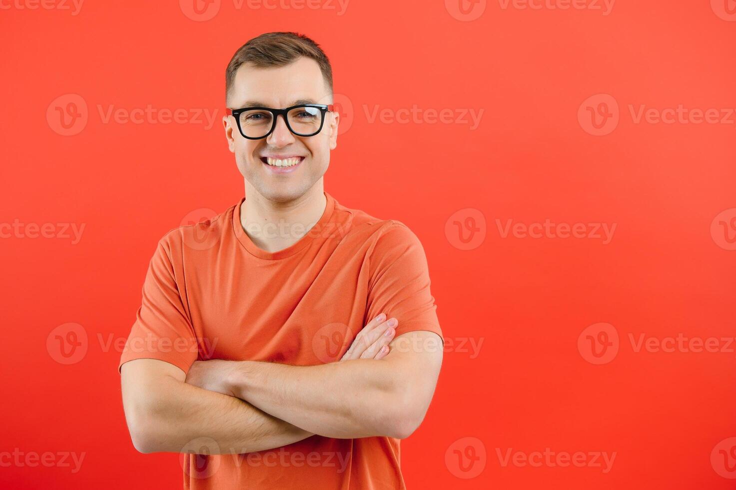 giovane bello uomo indossare bicchieri e maglione in piedi al di sopra di rosso sfondo con un' contento e freddo Sorridi su viso. fortunato persona. foto