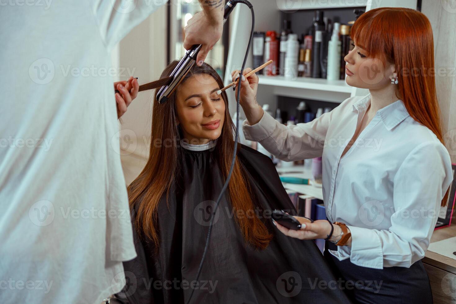 bellezza salone lavoratori trucco artista e parrucchiere preparare femmina cliente per evento foto