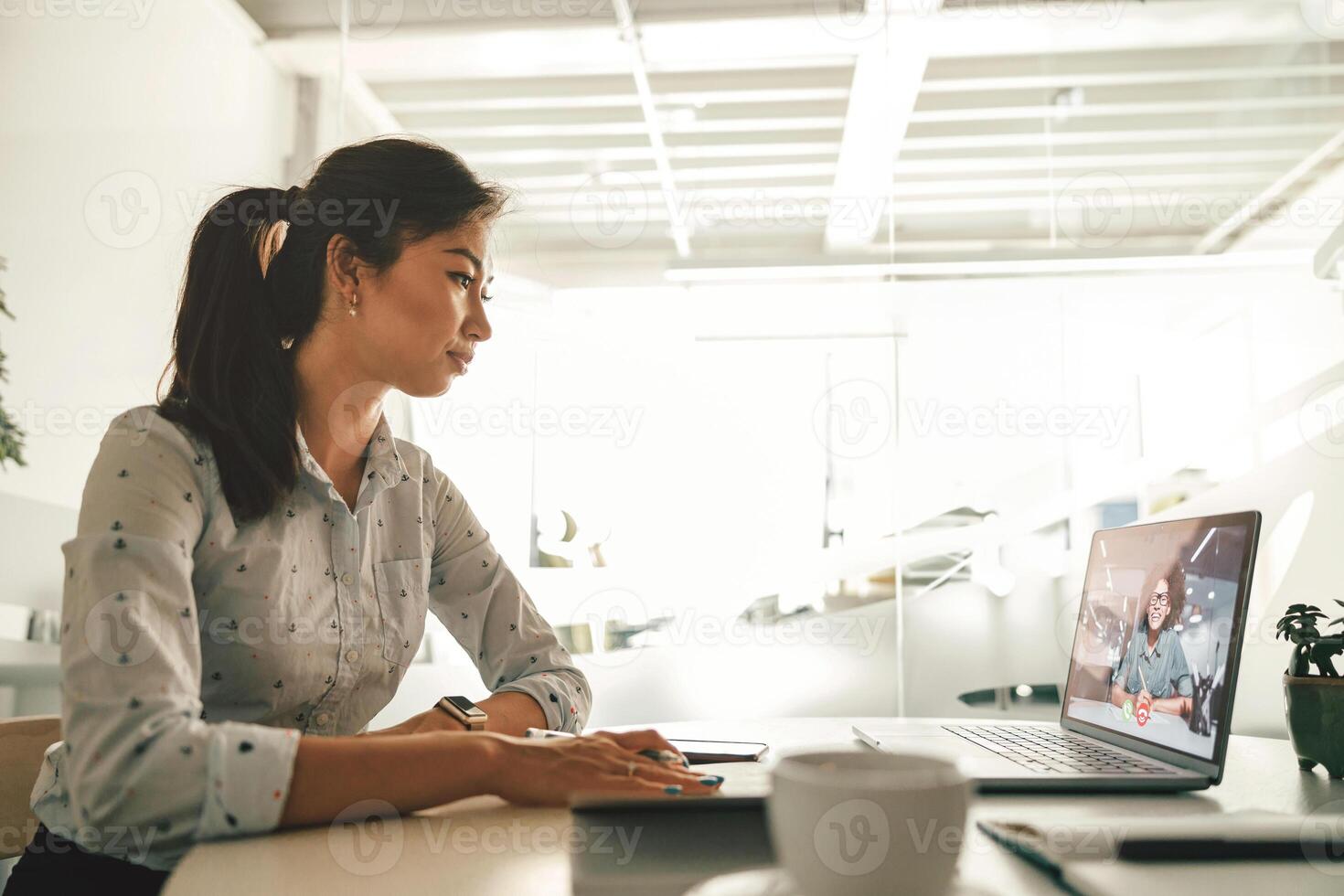 donna d'affari durante in linea video conferenza con collega mentre seduta nel ufficio foto