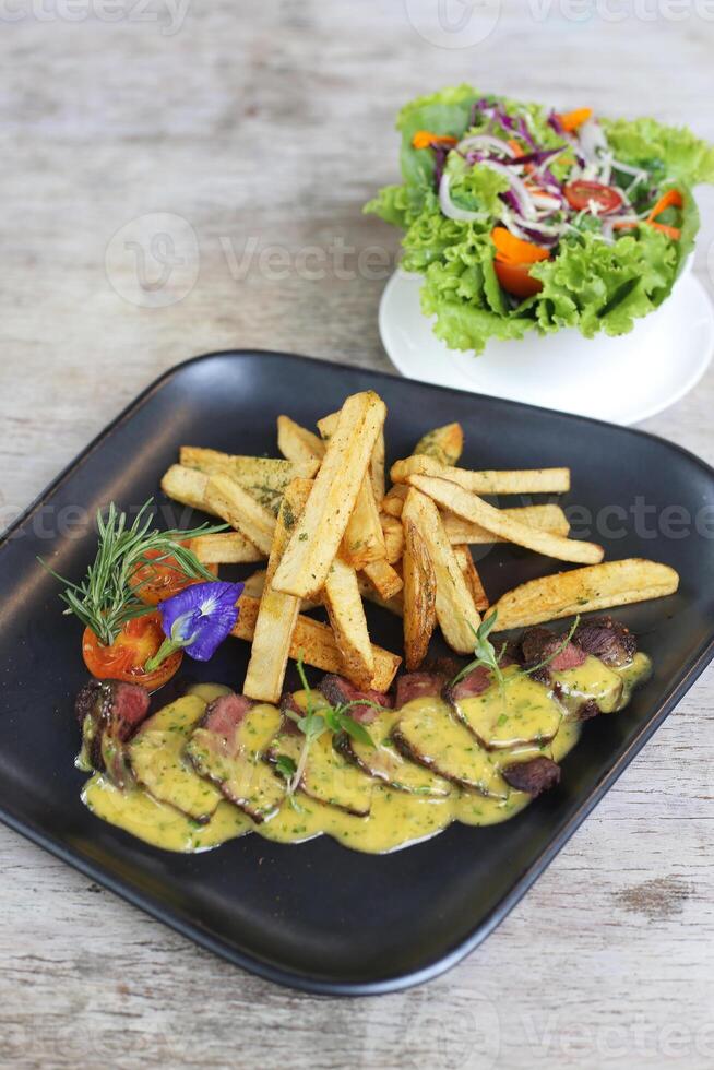bistro bistecca frites con insalata servito nel un' piatto isolato su grigio sfondo lato Visualizza foto