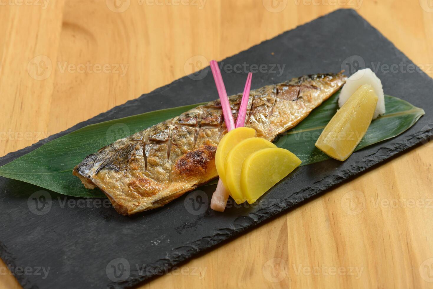 giapponese cibo grigliato saba pesce shioyaki con lime nel un' piatto isolato su di legno sfondo superiore Visualizza foto