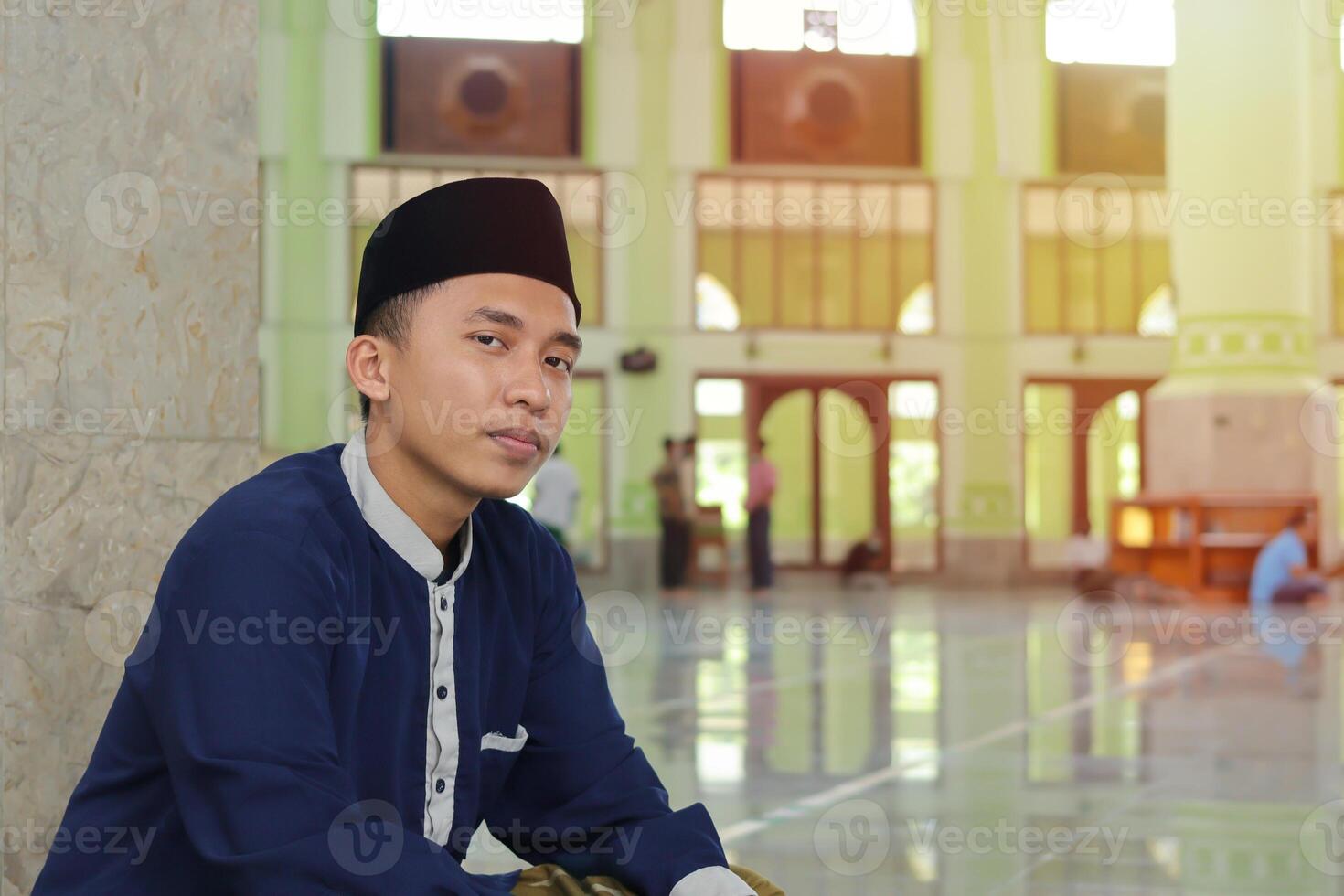 ritratto di religioso asiatico uomo nel musulmano camicia seduta nel moschea foto