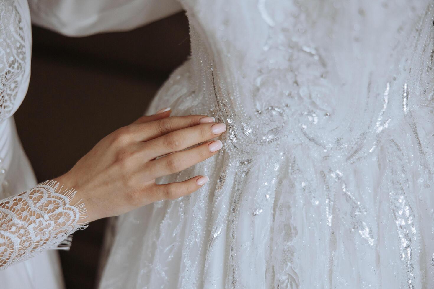 sposa toccante sua nozze vestire. alto qualità foto. un' bellissimo giovane sposa nel un' bianca sottoveste è in piedi di il letto, toccante sua nozze vestire. foto