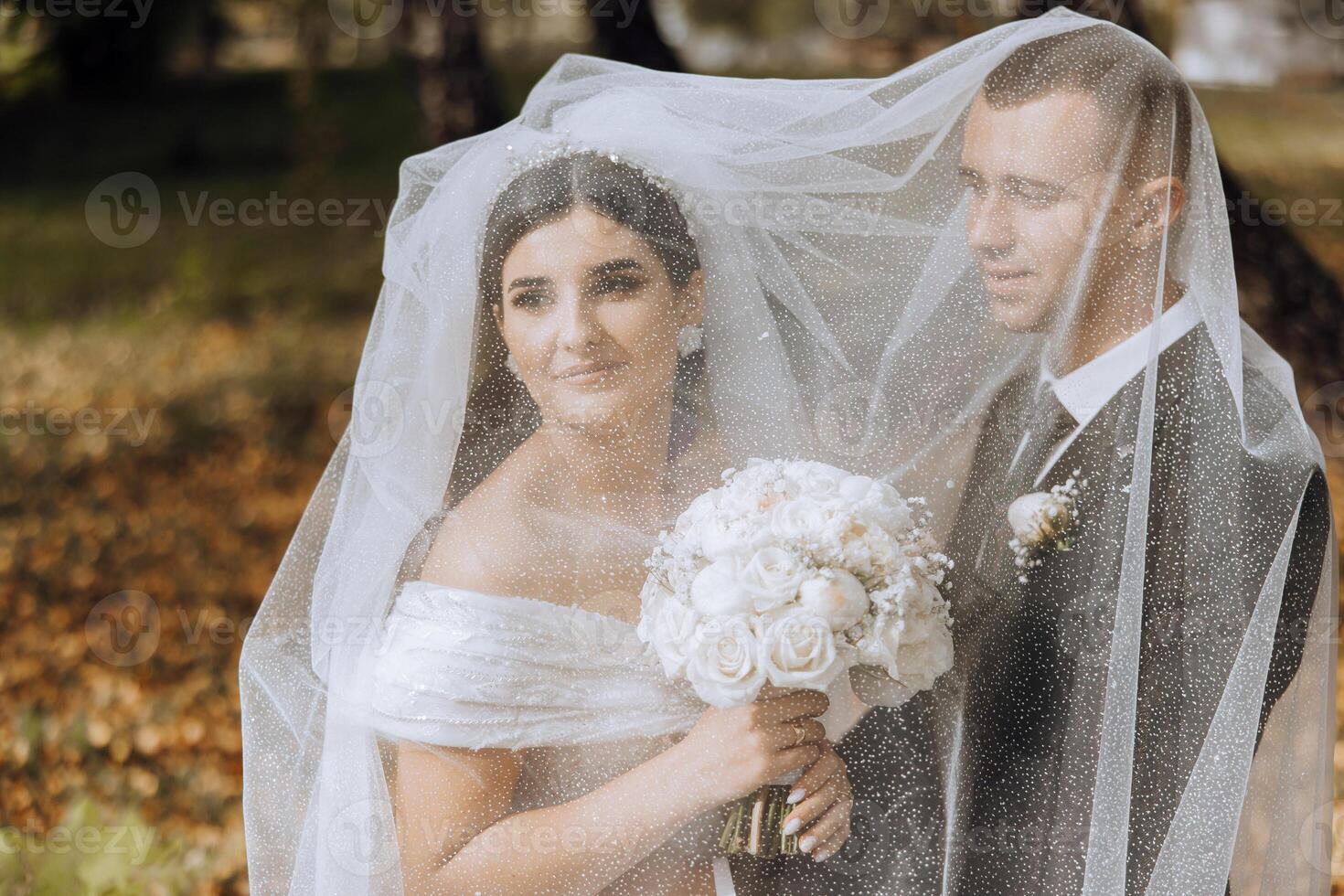 sono così lieto io sposato lui. ritagliata tiro di un affettuoso giovane sposa sorridente Abbracciare una persona sua sposo sotto un' velo su loro nozze giorno. foto