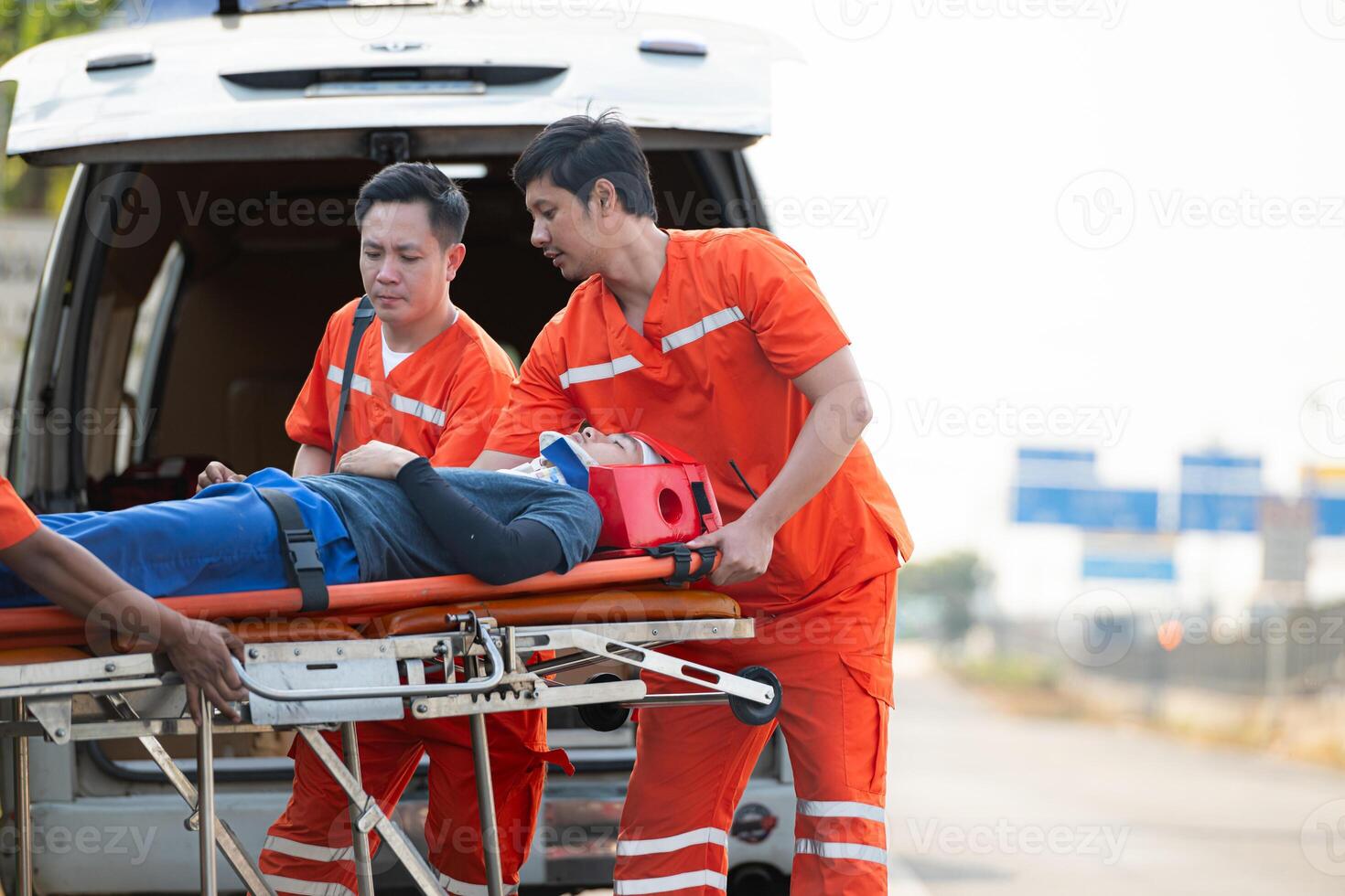 il paramedico è assistere un ferito uomo nel un emergenza situazione su il strada. foto