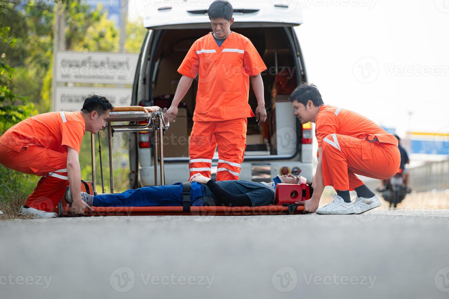 il paramedico è assistere un ferito uomo nel un emergenza situazione su il strada. foto