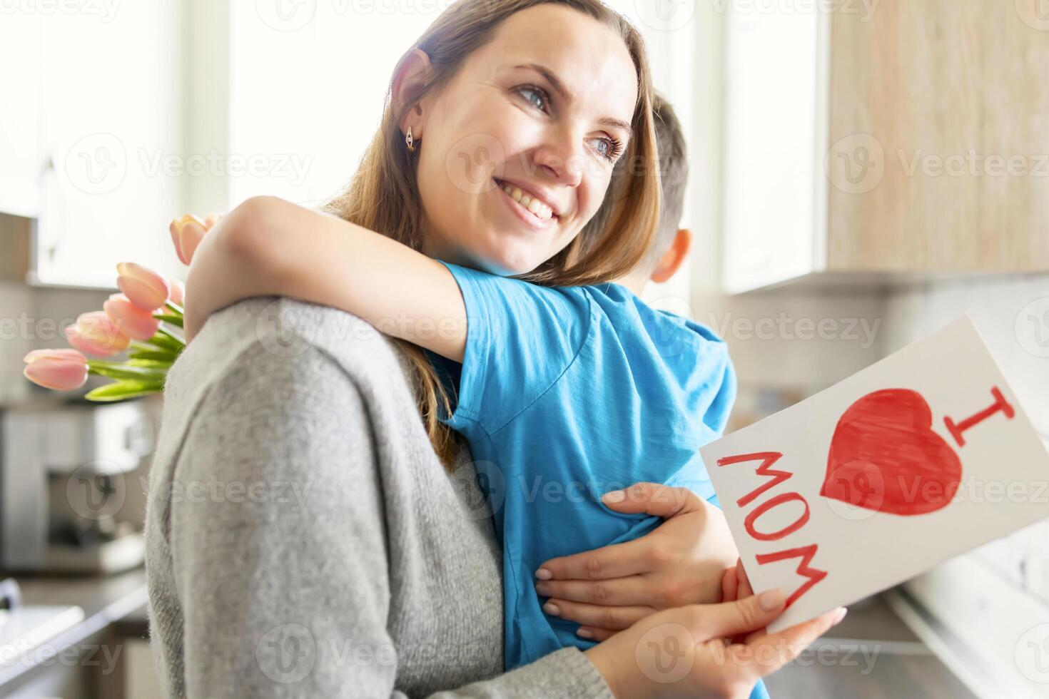 figlio si congratula mamma e dà sua carta e un' mazzo di fiori per tulipani foto