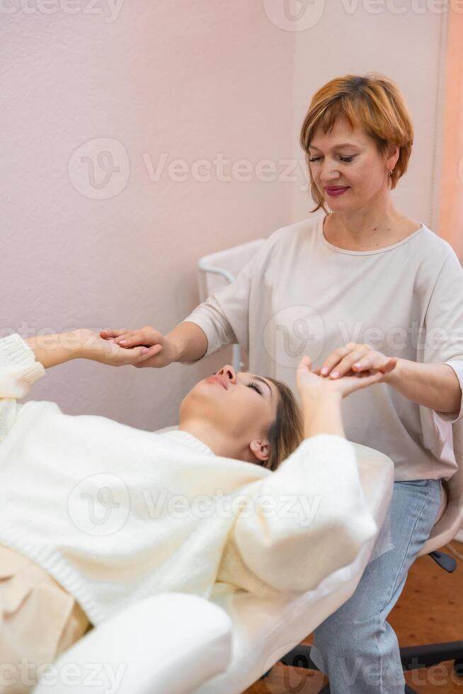 guaritore donna lancia corpo energia attraverso mani prima accesso barre terapia con giovane donna, stimolante positivo modificare pensieri e emozioni. alternativa medicina concetto. foto