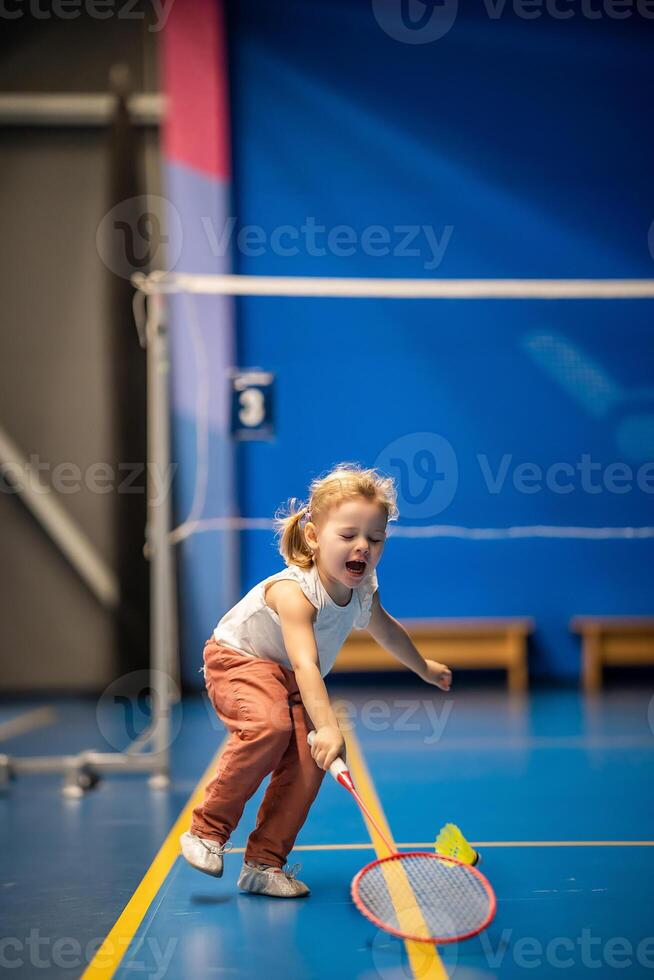 poco ragazza tre anni vecchio giocando badminton nel sport indossare su interno Tribunale foto