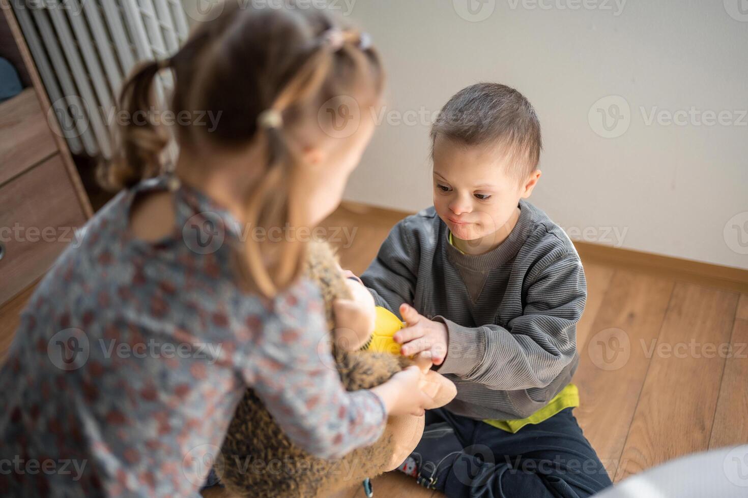 piccolo ragazzo con giù sindrome giochi con il suo minore sorella nel casa Camera da letto. alto qualità foto