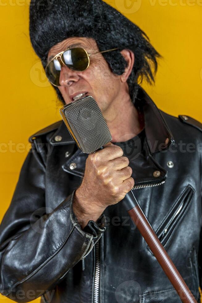 divertente ritratto di maturo rocker. un vecchio cantante vestito nel rockabilly stile nel azione foto