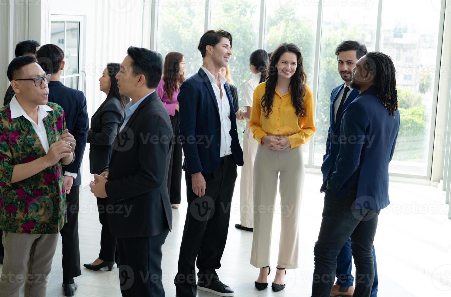 un' gruppo di persone siamo in piedi nel un' camera, alcuni di loro indossare tute e cravatte. essi siamo tutti sorridente e sembrare per essere godendo ogni altri azienda. il atmosfera è amichevole e rilassato foto