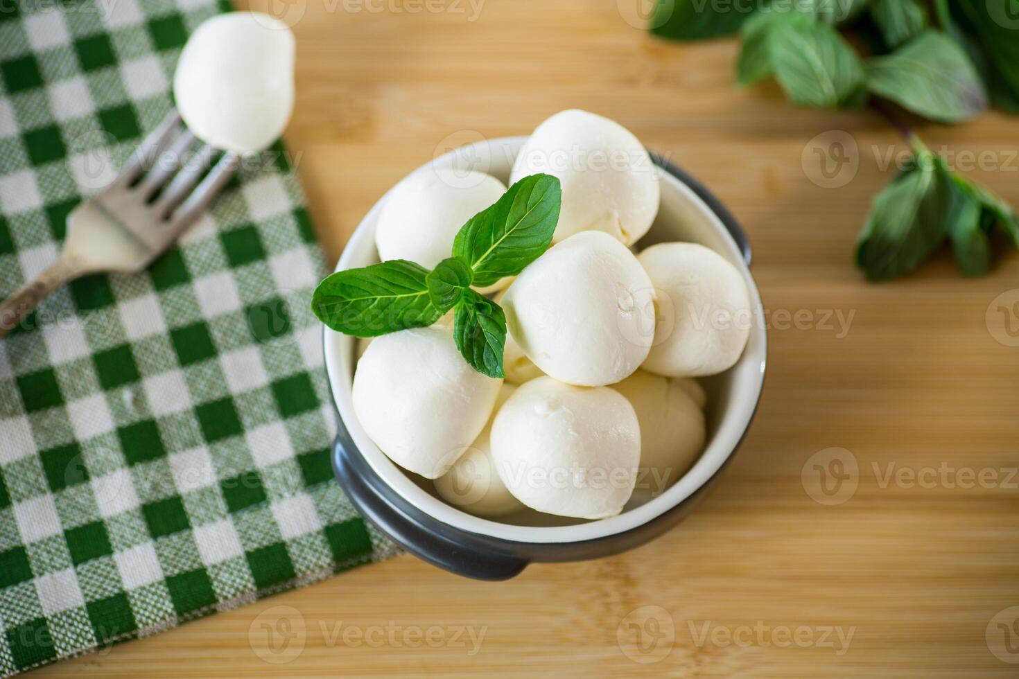 piccolo palle di tradizionale Mozzarella nel un' ceramica ciotola foto