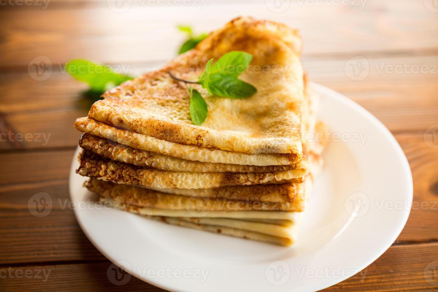 lotto di magro Pancakes nel un' piatto, su di legno tavolo. foto