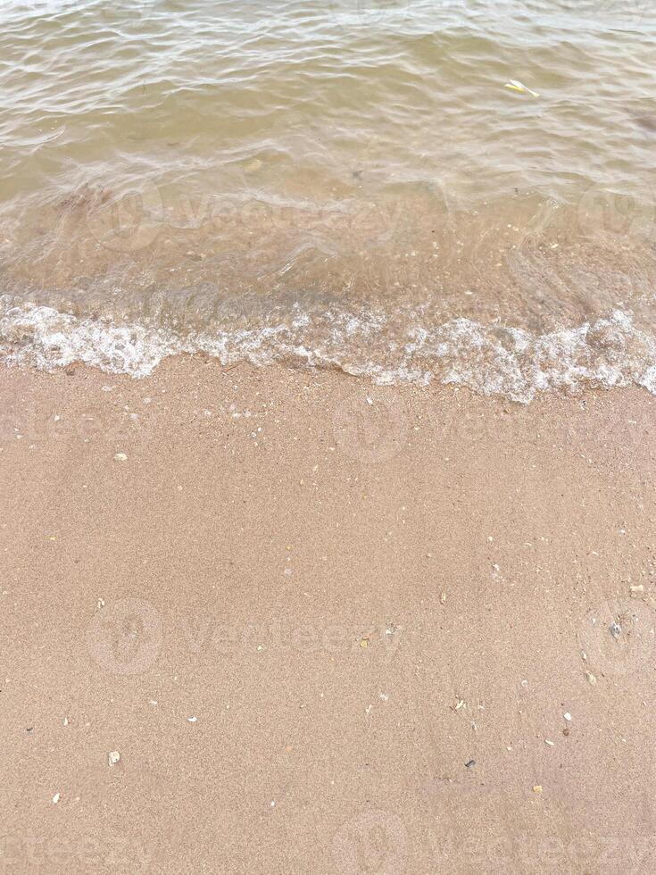 morbida onda dell'oceano blu sulla spiaggia sabbiosa. sfondo. foto