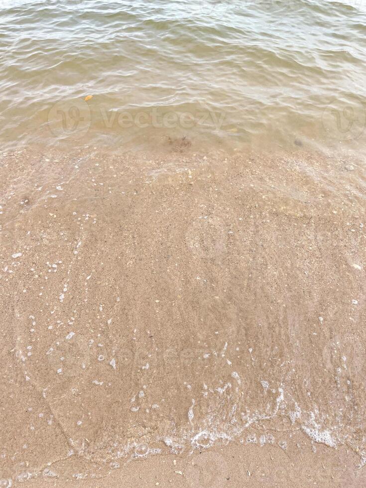 morbida onda dell'oceano blu sulla spiaggia sabbiosa. sfondo. foto