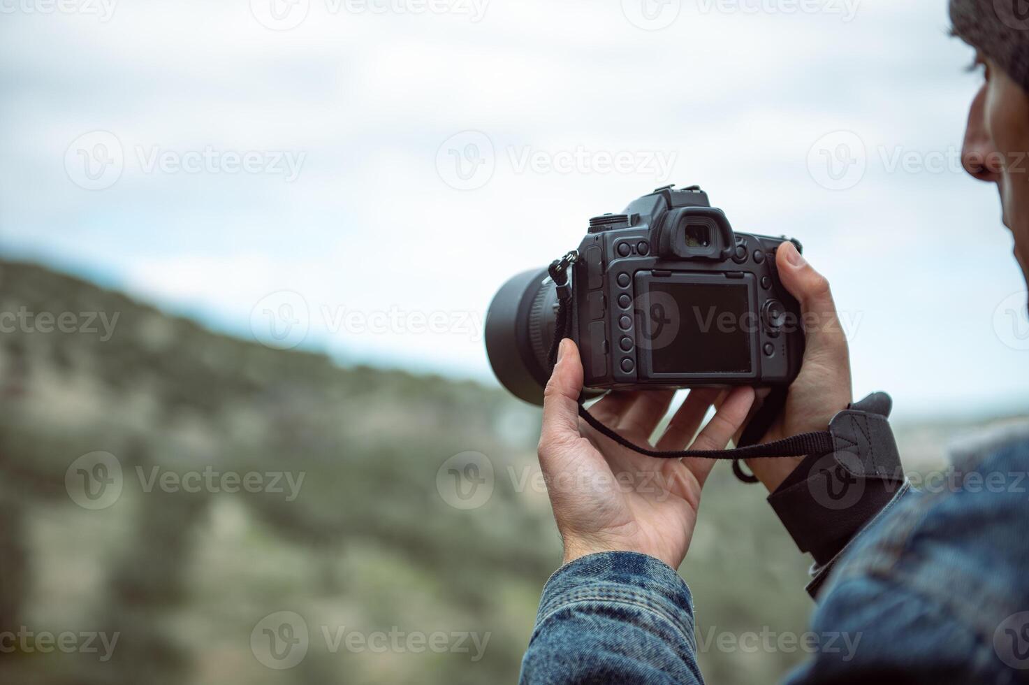 dettagli su il digitale telecamera nel il mani di maschio fotografo cattura il bellezza di natura, Fotografare montagne foto