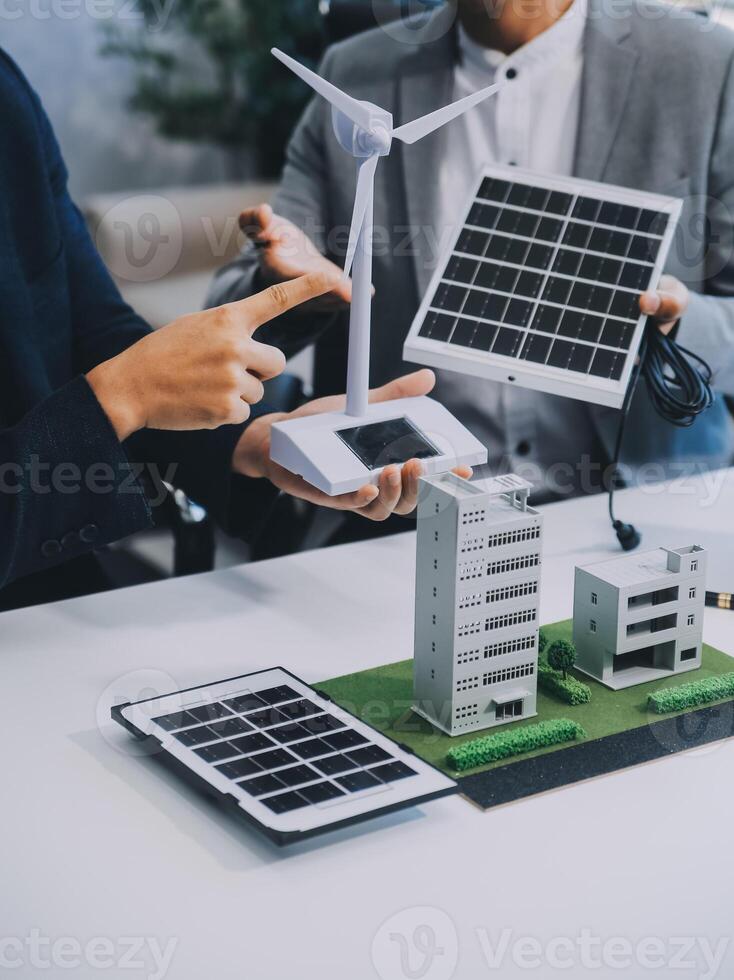 Due giovane ingegneri competenza nel solare cellula installazione incontri e discussione nel il lavoro. pianificazione per installare solare fotovoltaico pannelli su tetto superiore nel il ufficio camera con fabbrica edificio Piano. foto