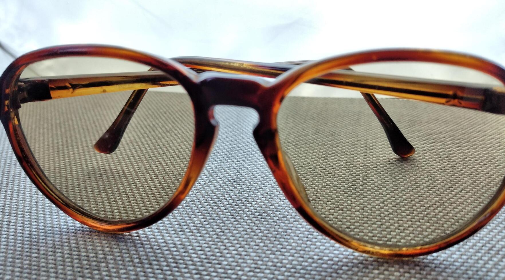 occhiali da sole con Marrone bicchieri nel un ferro telaio su un' grigio sfondo foto