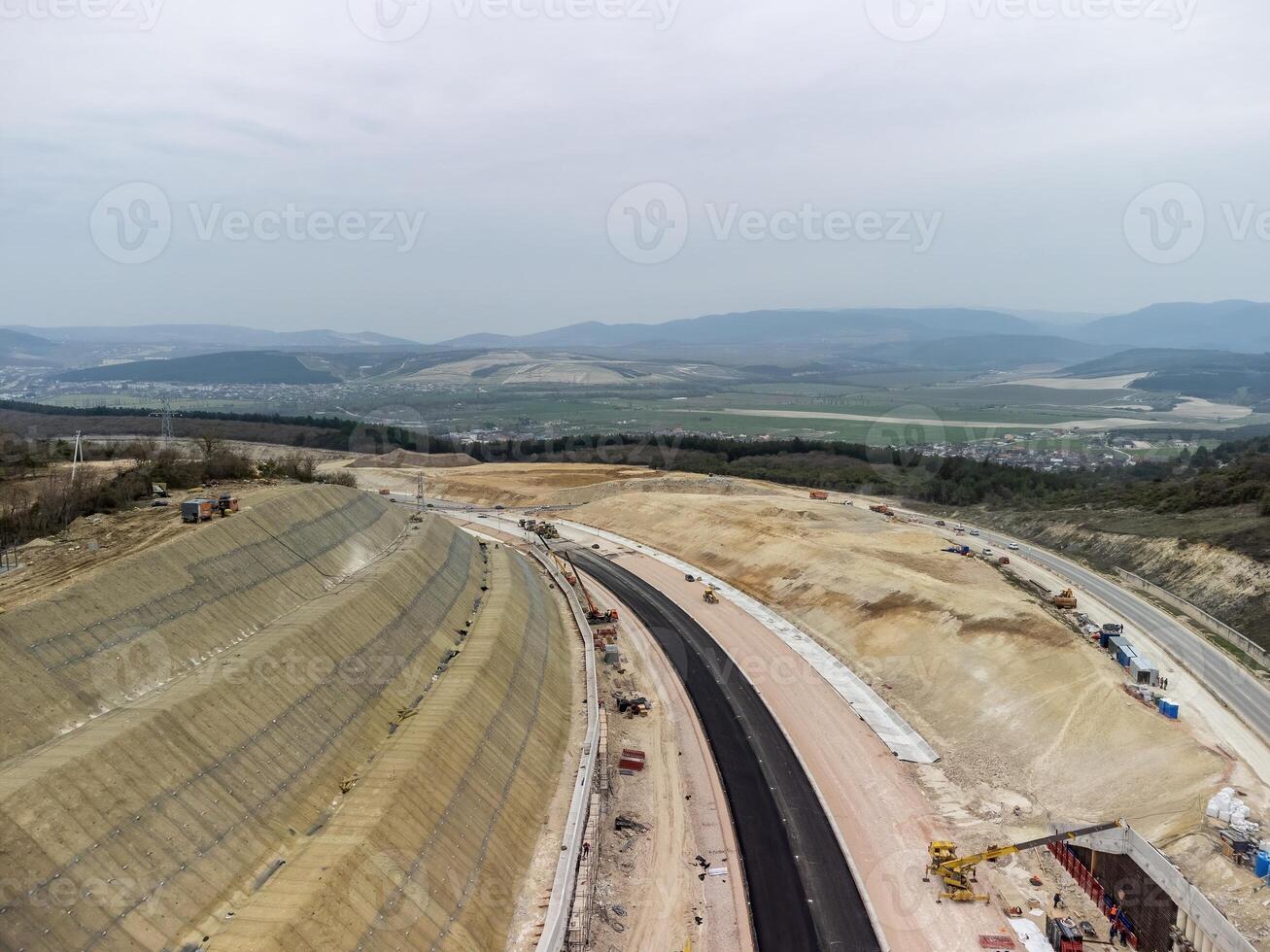 montagna strada costruzione. lavoratori rafforzare il pendenza al di sopra di il nuovo strada. strada costruzione nel progresso su pendenza natura canyon. infrastruttura sviluppo e la logistica. aereo fuco tiro foto