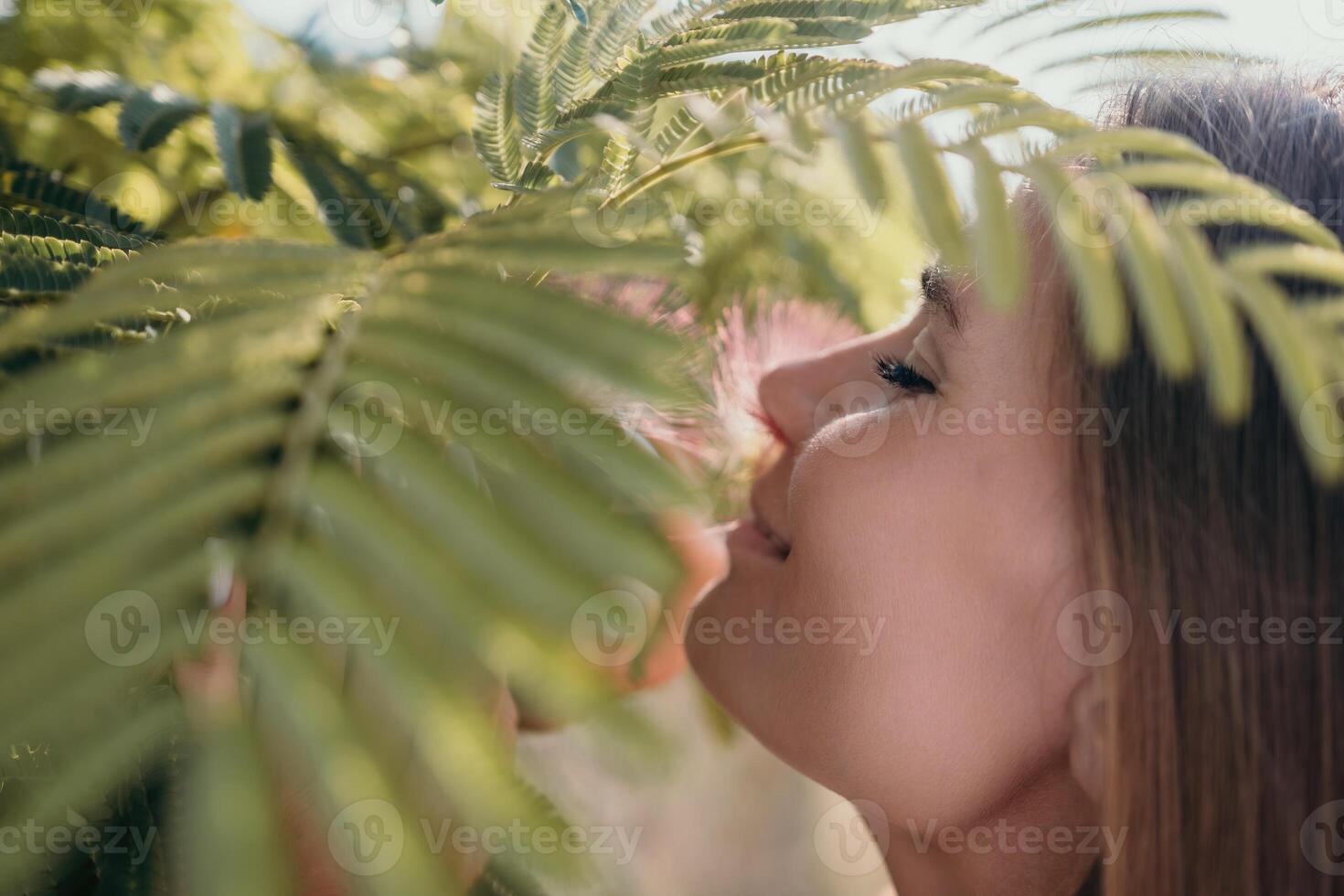 bellezza ritratto di contento donna avvicinamento. giovane ragazza odorare Cinese acacia rosa fioritura fiori. ritratto di giovane donna nel fioritura molla, estate giardino. romantico vibrazione. femmina e natura foto