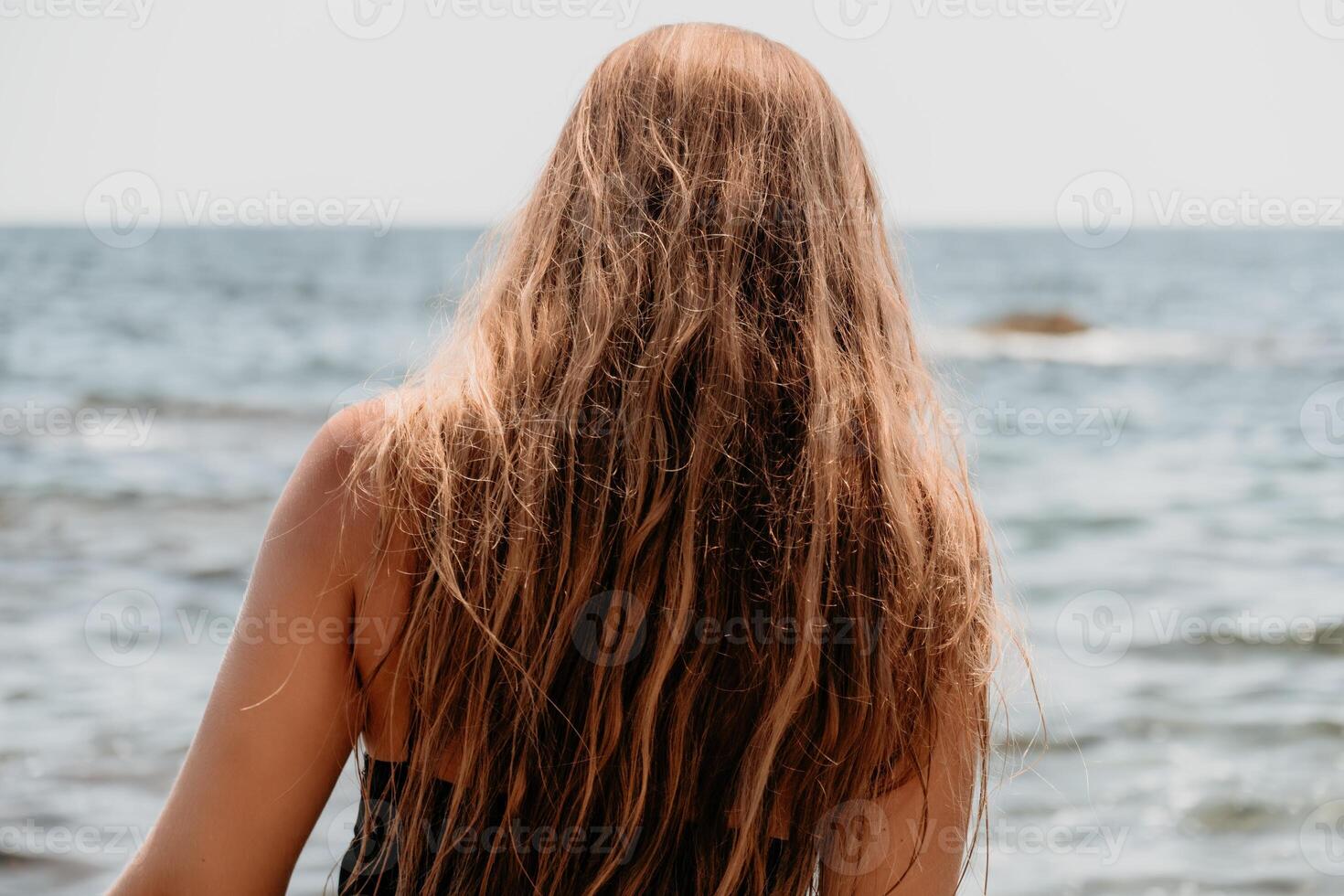 donna estate viaggio mare. contento turista nel cappello godere assunzione immagine all'aperto per ricordi. donna viaggiatore in posa su il spiaggia a mare circondato di vulcanico montagne, condivisione viaggio avventura viaggio foto