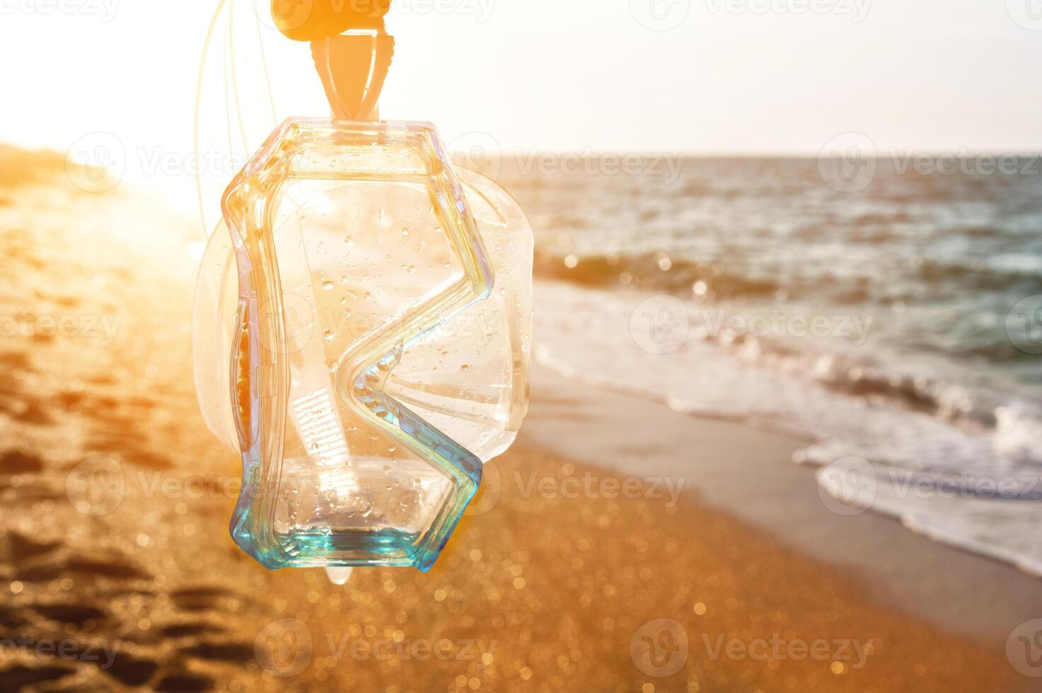 subacqueo maschera per lo snorkeling contro il fondale di tramonto sabbioso riva e mare foto