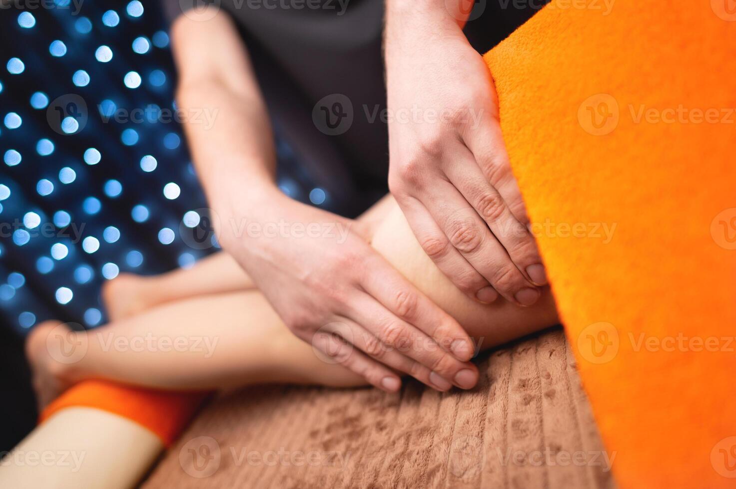 donna è dato un' rilassante massaggio con essenziale oli, un' uomo massaggio terapista impasta sua cosce con il suo mani, anticellulite procedure foto