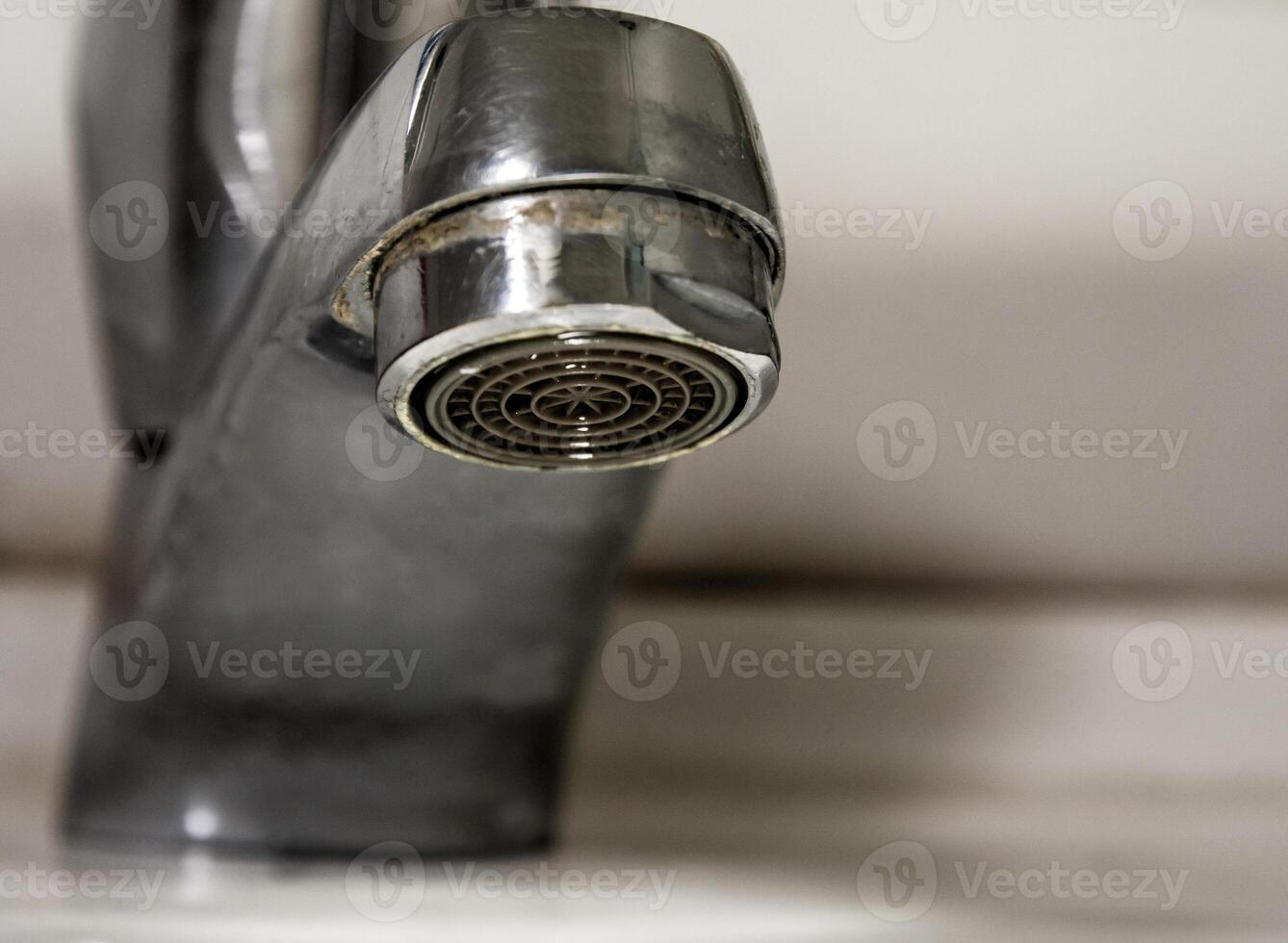 gocce d'acqua che perdono dalla vecchia ruggine e dal rubinetto macchiato foto